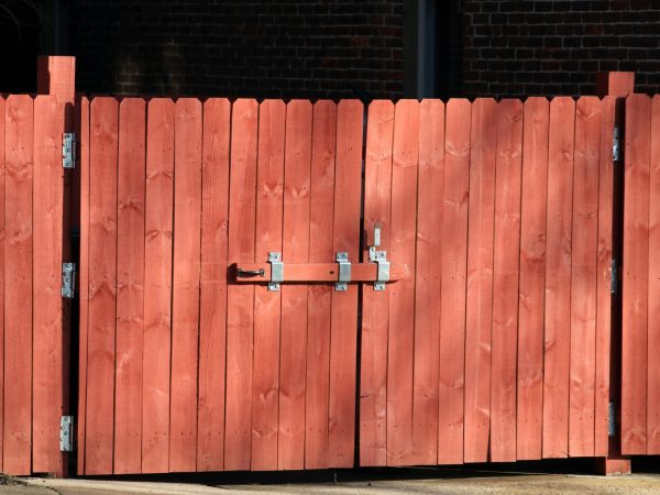 pexels photo 18900649 18900649 Rustic red wooden fence with a metal latch, ensuring safety and security outdoors.